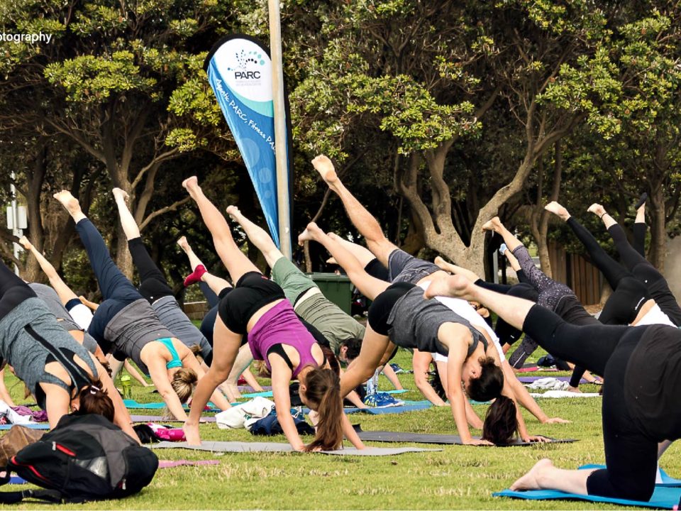 People doing yoga outside on the grass